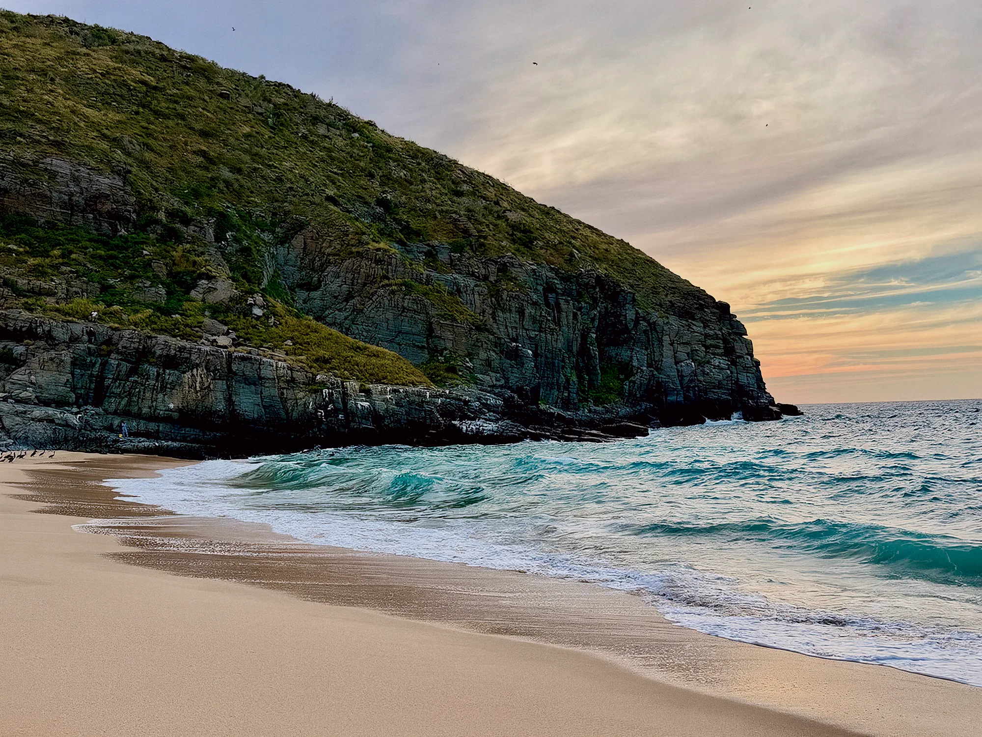Bahía dorada al atardecer frente al acantilado de Punta Lobos